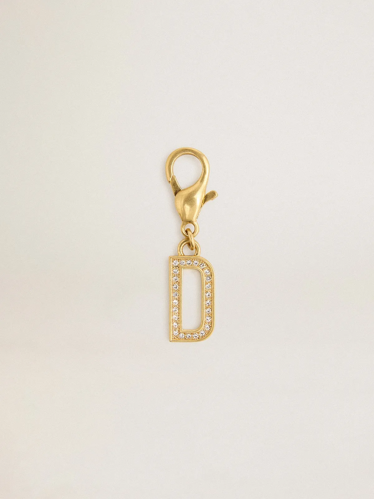 Dije de latón con forma de letra D color dorado con cristales