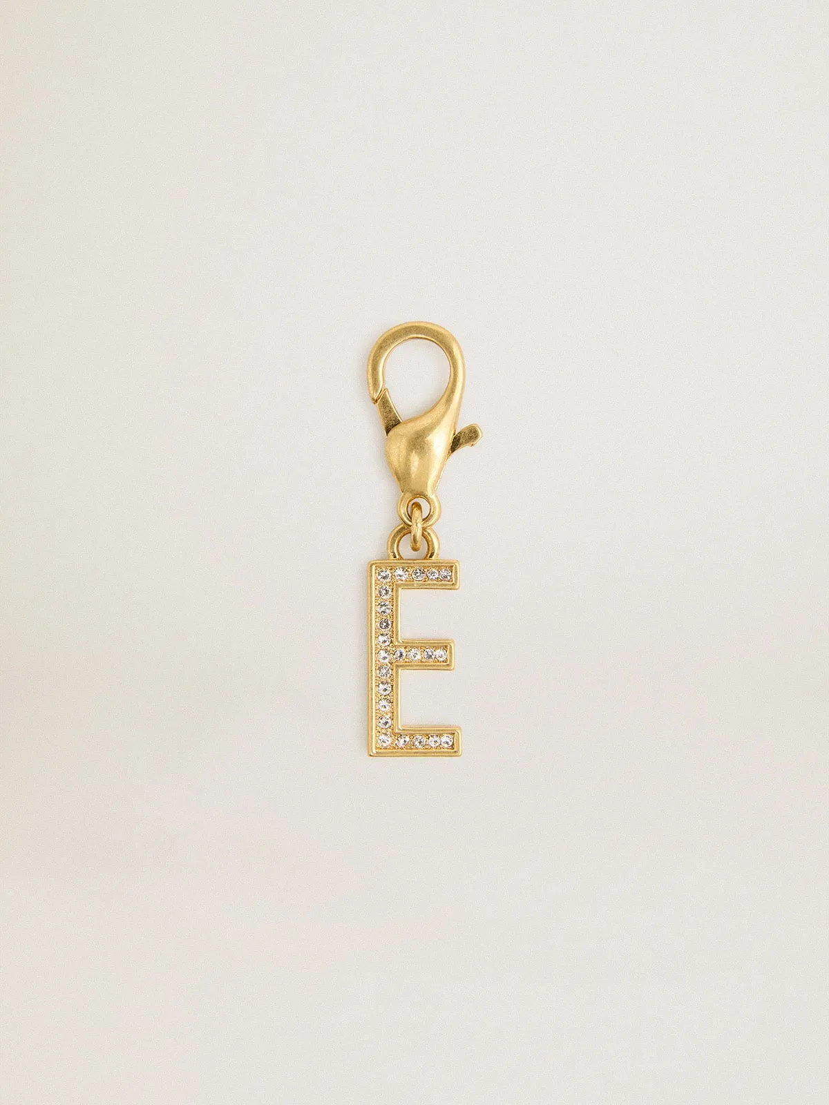 Dije de latón con forma de letra E color dorado con cristales