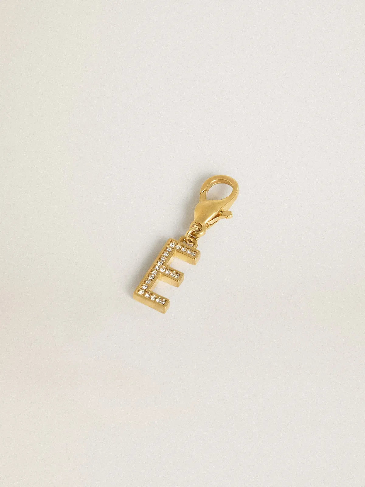 Dije de latón con forma de letra E color dorado con cristales